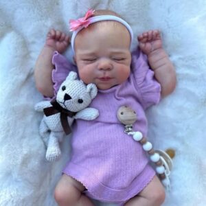 Bambola Reborn Alessandra 49cm viso sleeping con cerchietto rosa e vestitino lilla